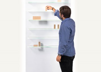 Expositor de melamina acabado blanco, con iluminación y seis niveles de exposición con baldas de cristal. Ideal para negocios como ópticas, farmacias, clínicas, diseñados por estudio AMA.