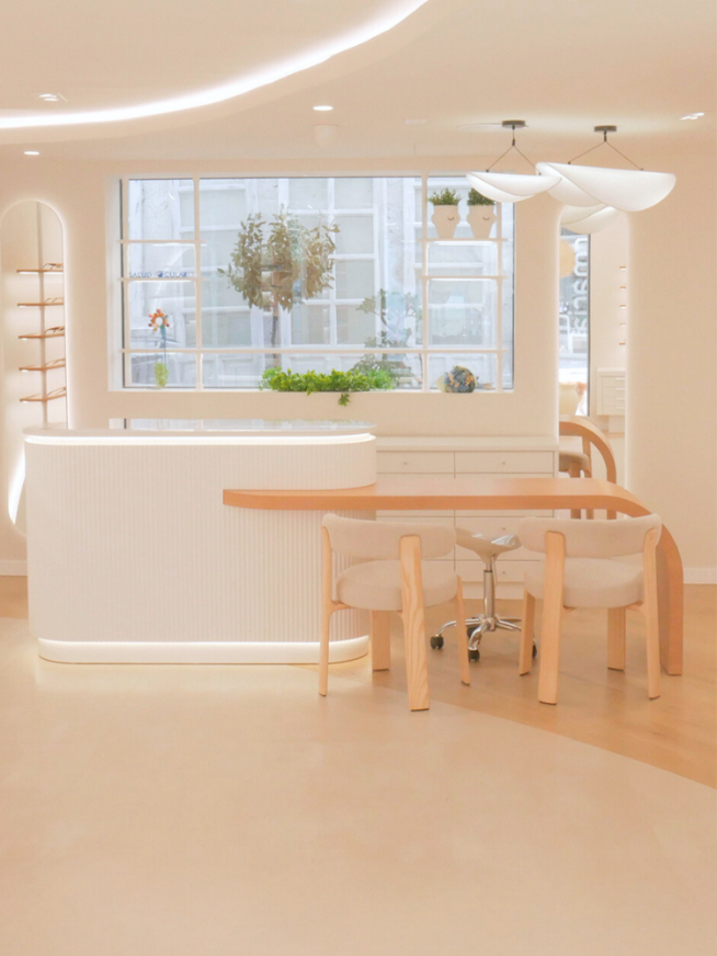 5 Mostrador en melamina, con cristal superior, iluminación y mesa de madera natural.